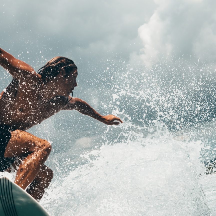Focus Under Pressure Surfer maintaining focus and balance while riding through a breaking wave