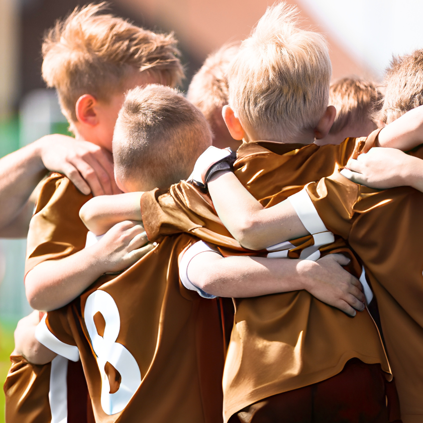 FUN360° Academy Soccer boys hugging in a huddle after a win and having fun